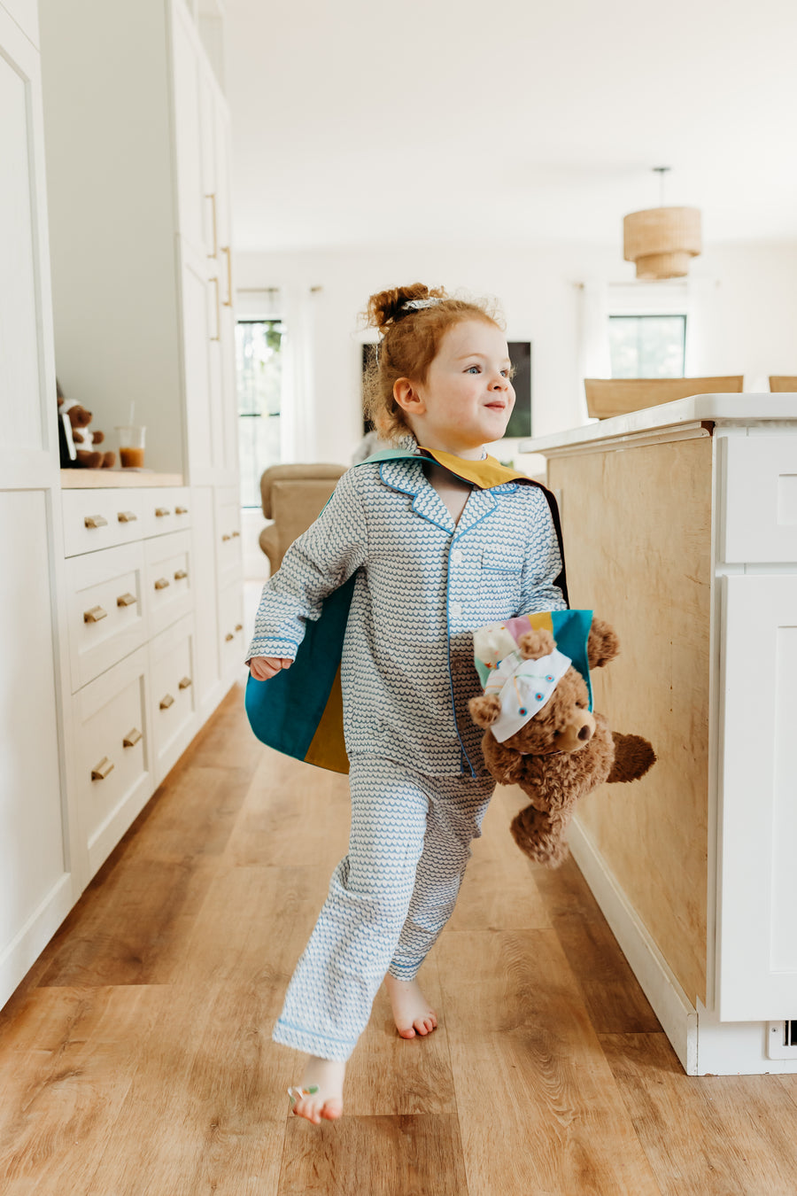 Girl running at home with brave bear in hand